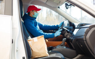 how much should you tip delivery drivers | man in red hat and blue coat making a food delivery