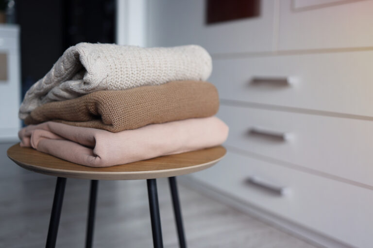 the fall edit | chair with three neutral colored folded garments