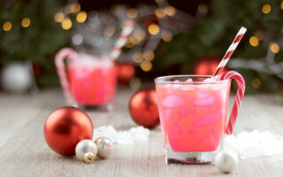 office holiday party | Two christmas party drinks with ice, straws and candy canes and sweets