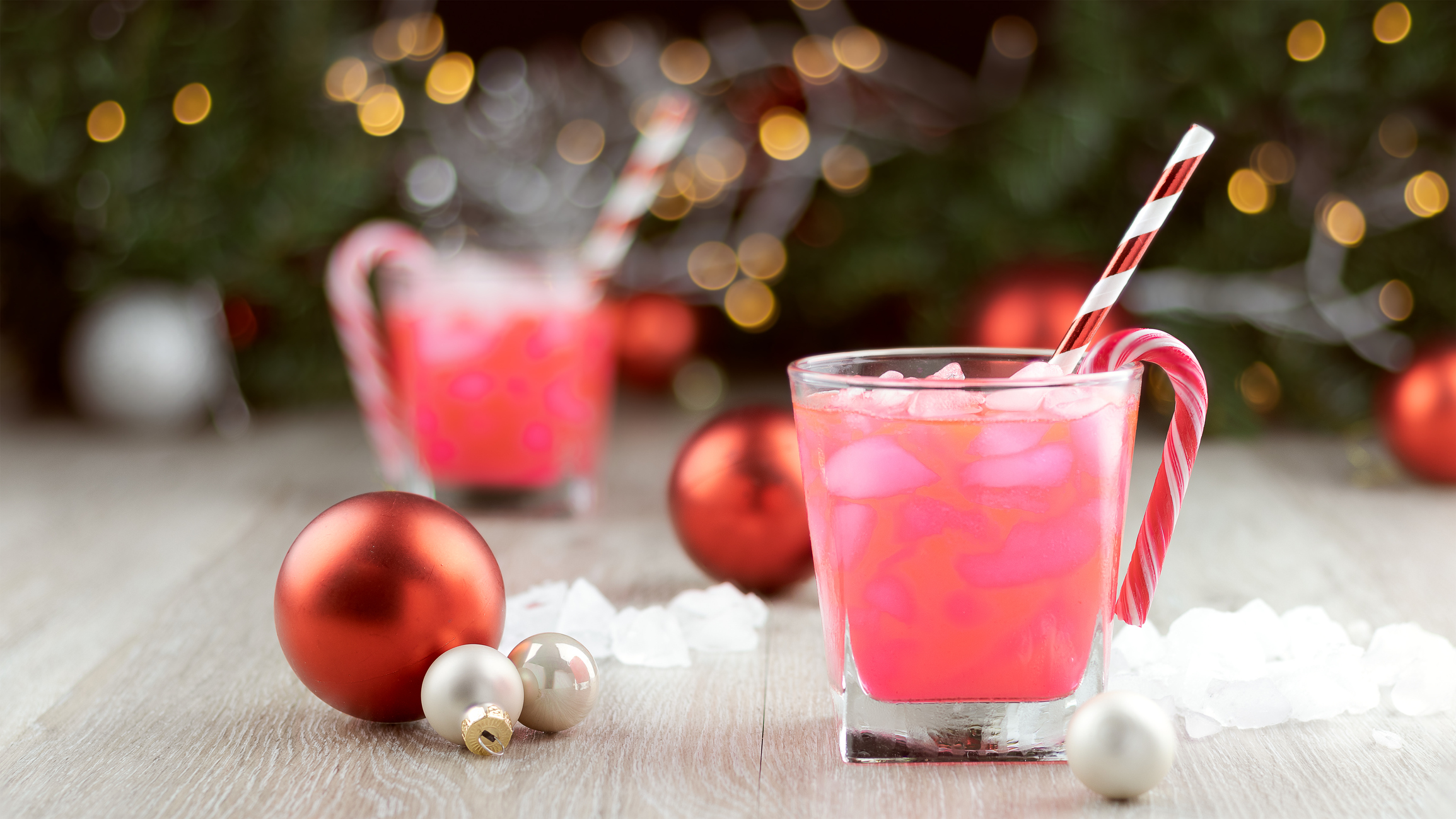 office holiday party | Two christmas party drinks with ice, straws and candy canes and sweets