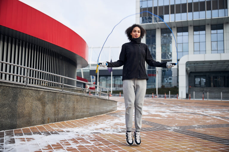 holiday blues | Adult female skipping up while rotating the jump rope and letting it pass under her feet