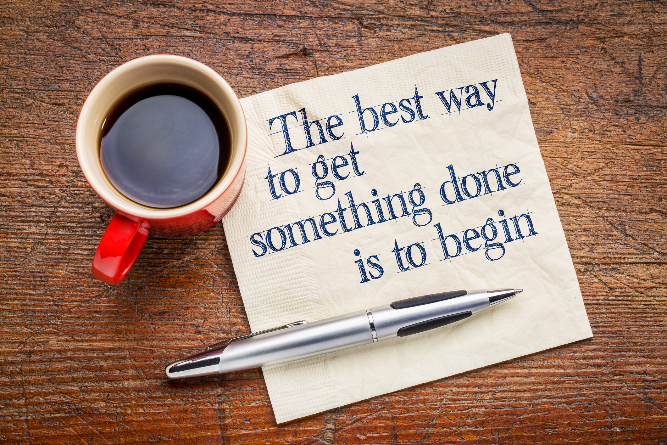 how to stop procrastinating | the best way to get something done is to begin - inspirational phrase on a napkin with cup of coffee 