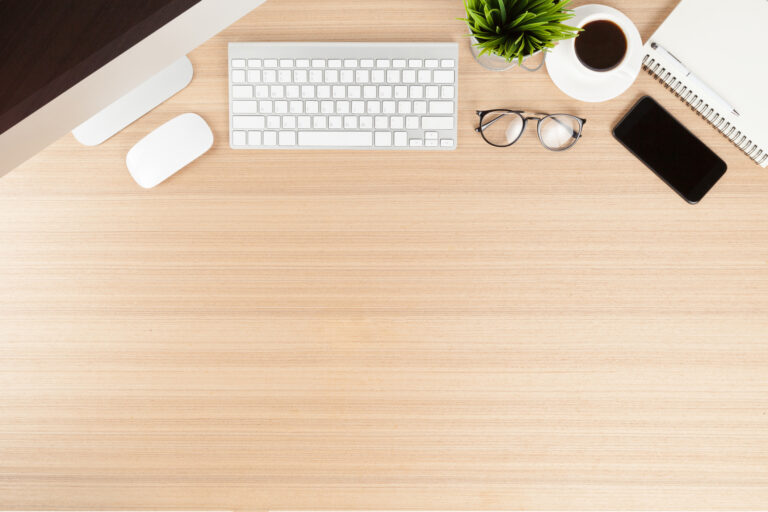 National Clean Off Your Desk Day | Overhead photo of organized desk with keyboard and phone