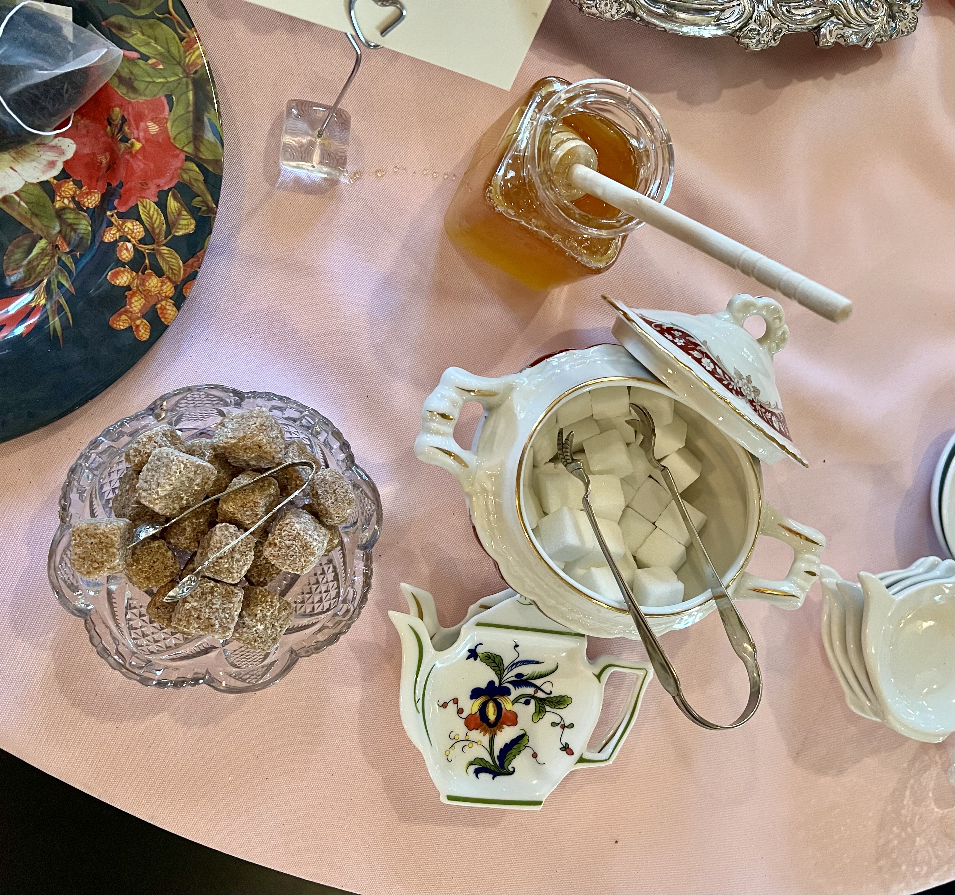 overhead photo of tea table with pink tablecloth and sugar cubes