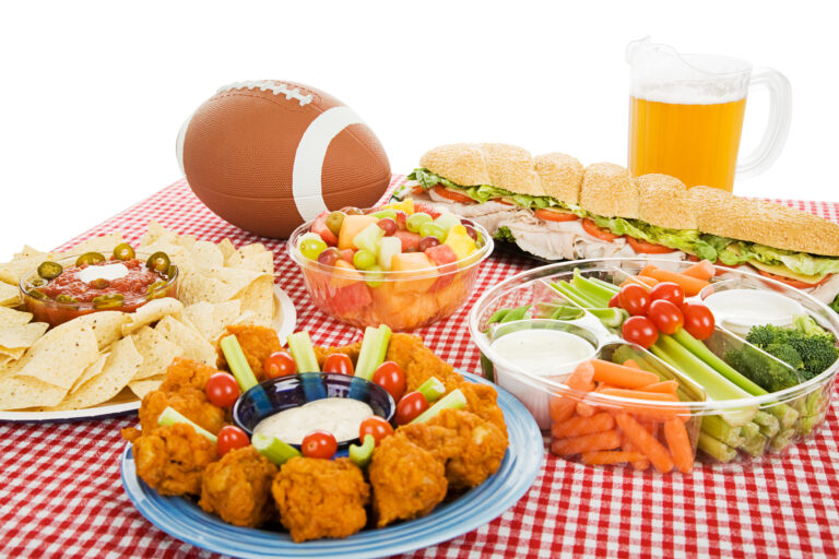 Super Bowl LVI etiquette | Table spread with appetizer trays for the footbal party. Horizontal view over white background