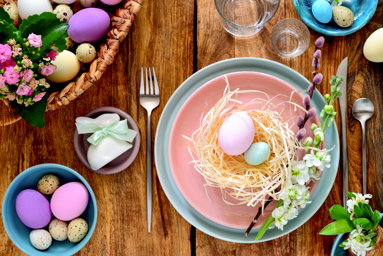Easter Entertaining Tips | Beautiful Easter place setting with a faux nest and eggs on a pink plate with a blue saucer