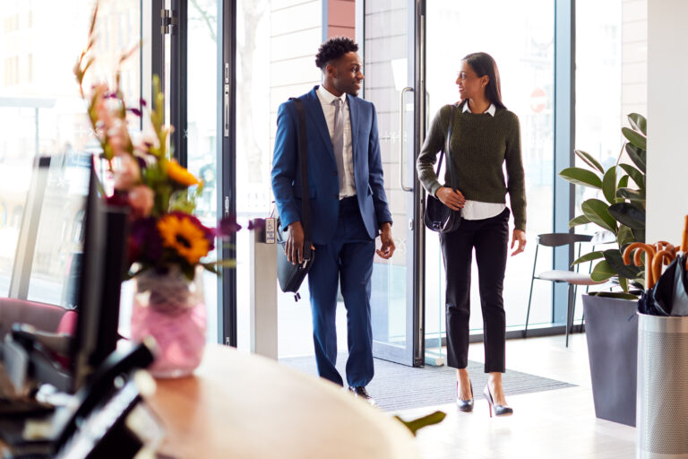internship etiquette | Businessman And Businesswoman Arriving For Work At Office Walking Through Door