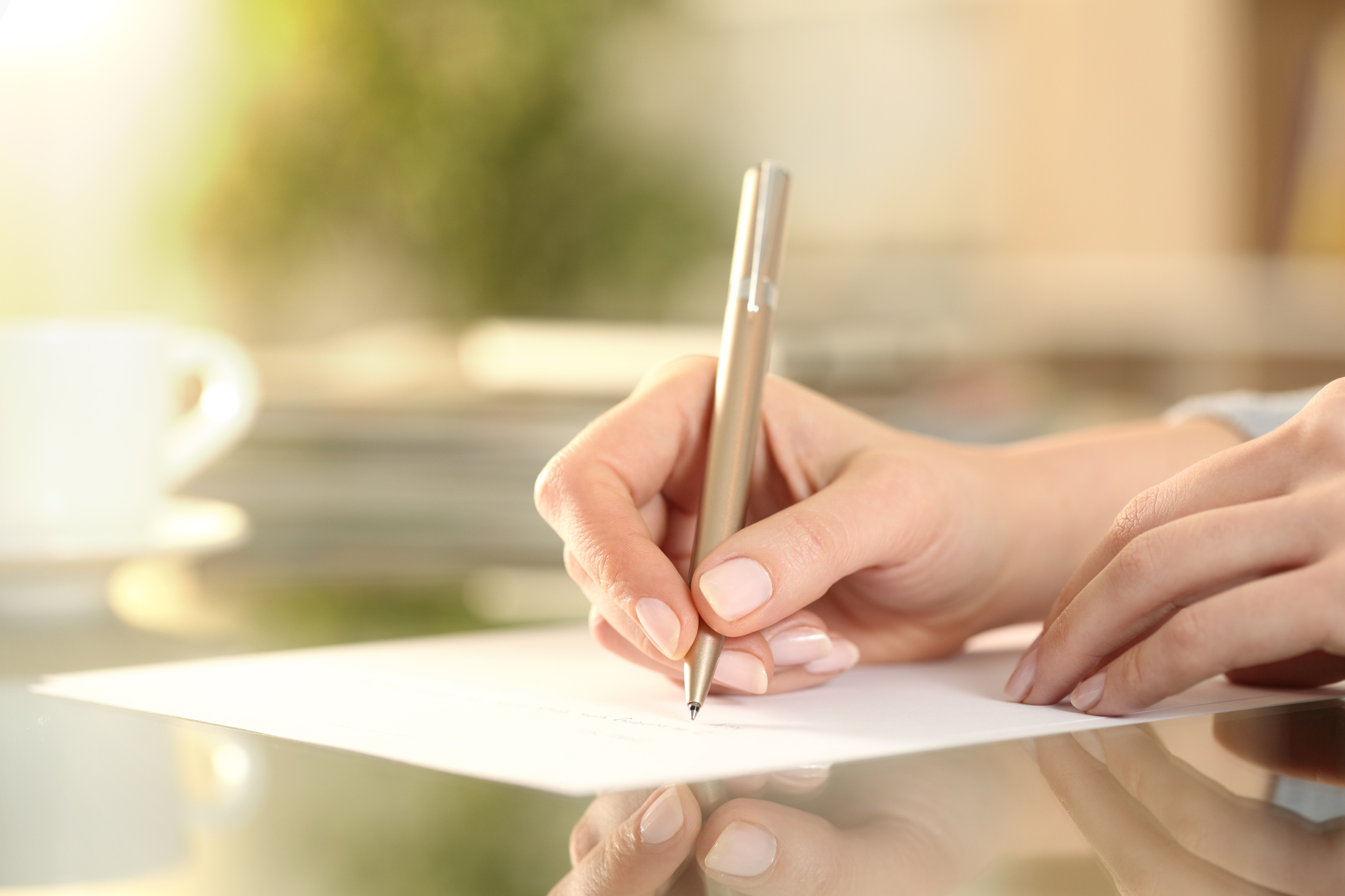 internship etiquette | Woman hand writing on a paper on a desk at home