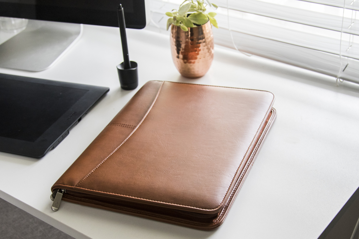 Graduation gift ideas | Brown leather business padfolio portfolio folder on sunny white office desk with computer and tablet