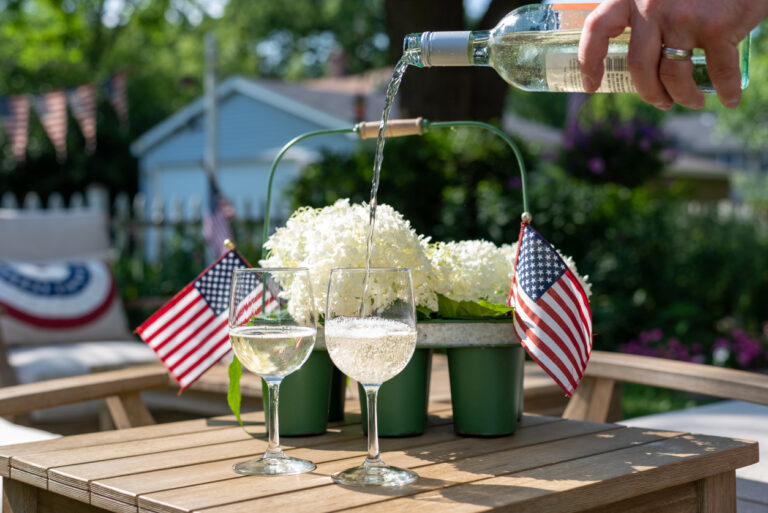 Outdoor Entertaining Etiquette | Pouring wine in the backyard on a summer day