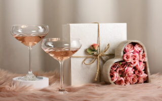 wedding season etiquette | Two glasses with rose wine and decorated gifts