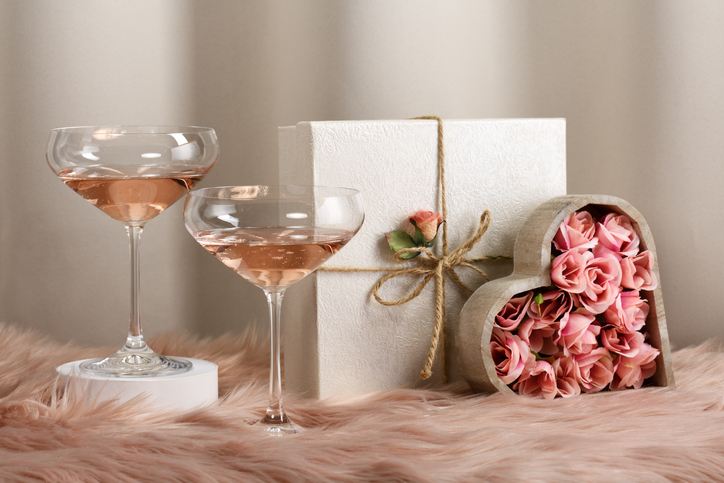 wedding season etiquette | Two glasses with rose wine and decorated gifts