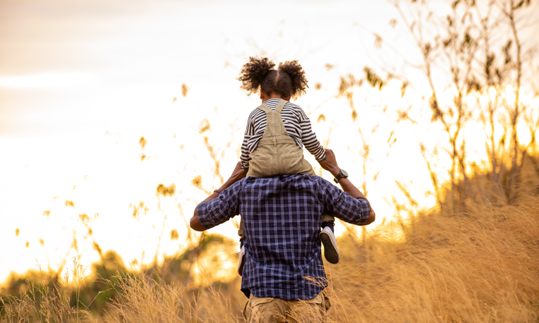 Father's Day Gift Ideas | Smiling father and little daughter carrying and hiking together on meadow hill in summer. Parent with cute child girl relax and enjoy outdoors lifestyle