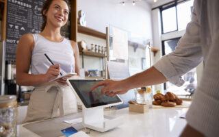 iPad Tipping Etiquette | Pressure Tipping Etiquette | Customer using touch screen to make payment at a coffee shop