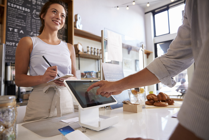 iPad Tipping Etiquette | Pressure Tipping Etiquette | Customer using touch screen to make payment at a coffee shop 