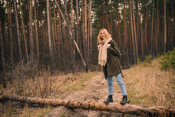 Fall Packing List | woman in blue jeans walking outdoors in the forest