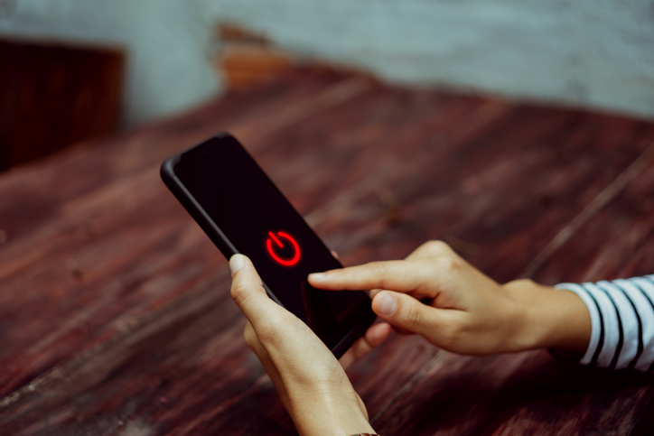 Woman hand using smartphone to switch off or shut down online and social connection. Business, financial, trade stock maket and social network concept.