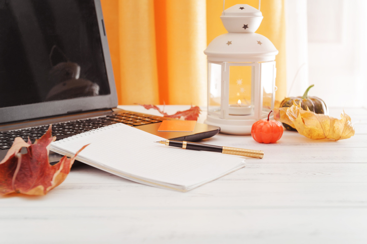 Update Your Desk For Fall | pen, notebook, laptop, pumpkin, leaves, candle on a white table, autumn composition
