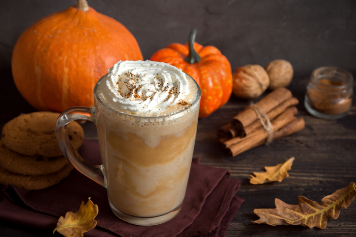 Pumpkin Spice Latte. Cup of Latte with Seasonal Autumn Spices, Cookies and Fall Decor. Traditional Coffee Drink for Autumn Holidays.