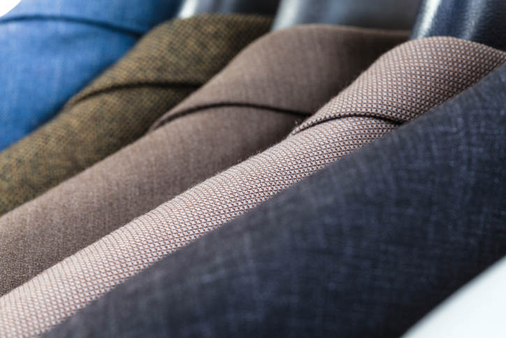 finished jackets on hangers in tailoring atelier close up