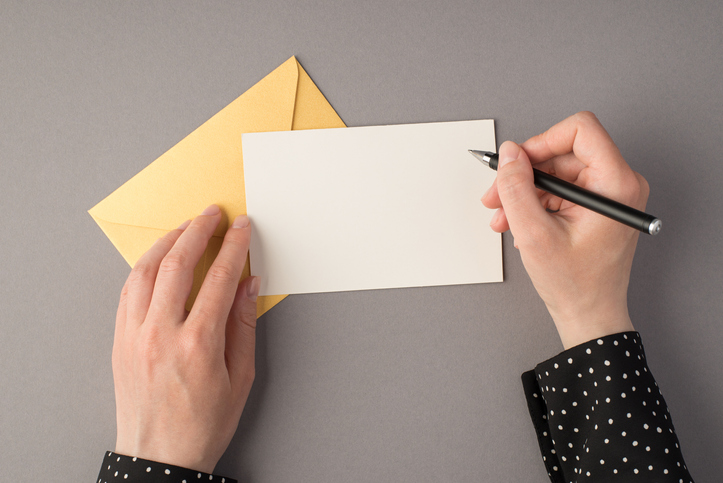 hand giving money in red envelope over white, Stock image