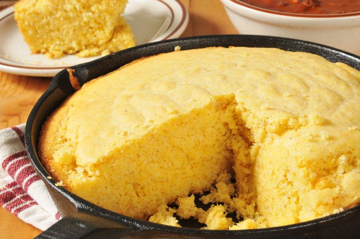 Southern Favorite Foods | Corn bread in a cast iron skillet with a bowl of chili in the background