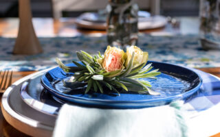 Spring Dining Etiquette | Rose buds on a blue luncheon plate in a dining room decorated for spring