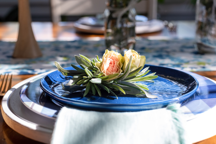 Spring Dining Etiquette | Rose buds on a blue luncheon plate in a dining room decorated for spring