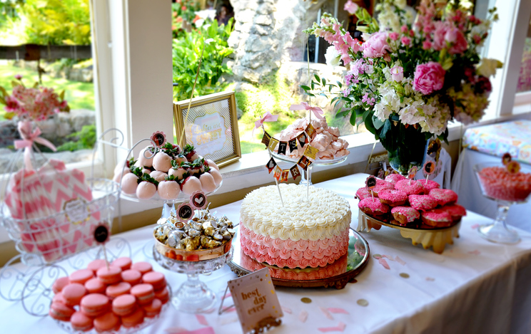 Spring and Summer Baby Shower Etiquette | Food table at a baby shower decorated with pink accents and fresh flowers 