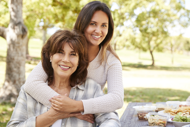 Mother's Day 2023 Ideas | Senior mother and adult daughter embracing in park, close up