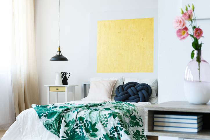 Houseguest Etiquette Reminders for Summer | Guest bedroom with green tropical bedding and yellow artwork