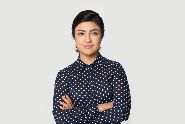 how to take the high road when someone is rude | Portrait of young successful woman worker employee stand isolated on grey studio background feel confident. Millennial mixed race female intern show motivation. Employment, hr concept.