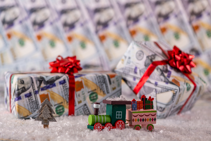 Holiday tipping guide 2023 | Toy wood train and gifts wrapped in wrapping paper with american dollars