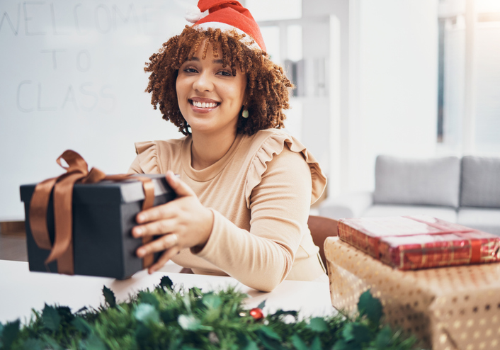 Christmas, box and portrait with a business black woman giving a gift at an office party or event. December, holiday and present with a female employee holding a giftbox while feeling happy