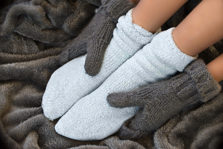 Feet in comfortable and warm woolen stocks on a blanket