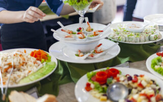 Cruise ship etiquette | Tourist cruise ships sailing among limestone mountains in Halong Bay, Vietnam, buffet in a cruise ship restaurant