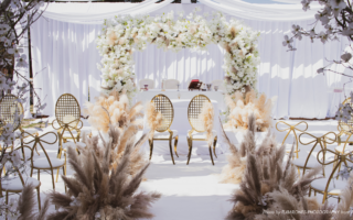 Wedding Etiquette Questions | An elegant wedding reception in whites and cream colors with bow shaped chair backs