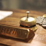 Hotel Etiquette Reminders | Hotel Front Desk with Brass Bell and Reception Sign