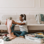 Labor Day Travel Etiquette | 2024 Tips from Etiquette Expert Diane Gottsman | Woman folding clothes into suitcase, neutral colors and sofa in background