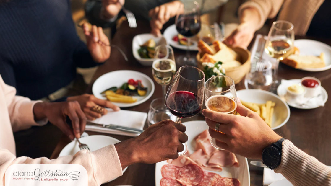 Friends with wine and appetizers around restaurant table (cropped)