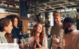 How to avoid getting stuck “splitting” the bill | friends out to dinner laughing and smiling around table