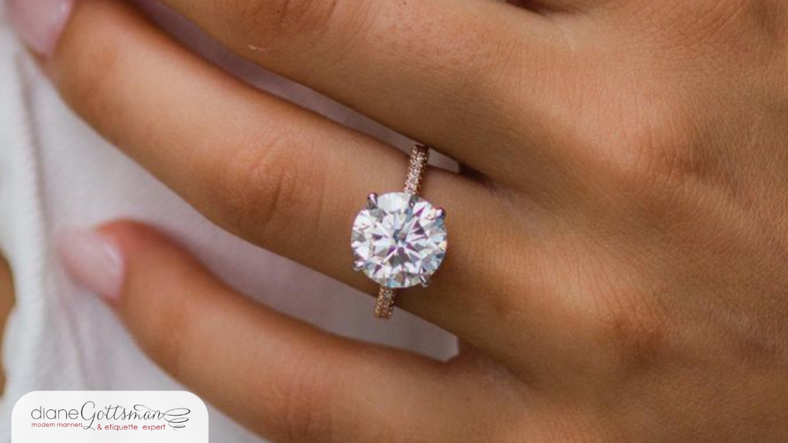 closeup of engagement ring on woman's hand, manicured nails