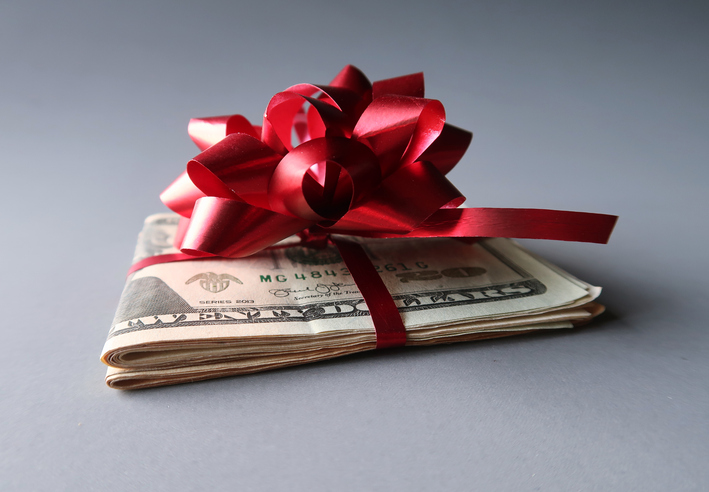 2024 Holiday Tipping Guide | Holiday Tipping Etiquette 2024 | Roll of cash with red bow 