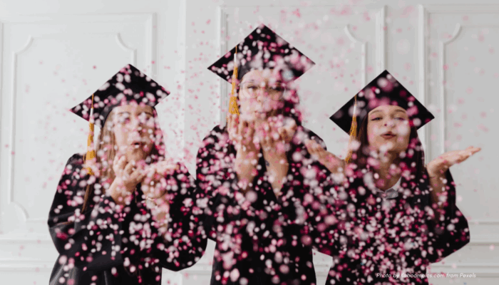 Graduation etiquette for parents | three graduates with caps and confetti, facing camera