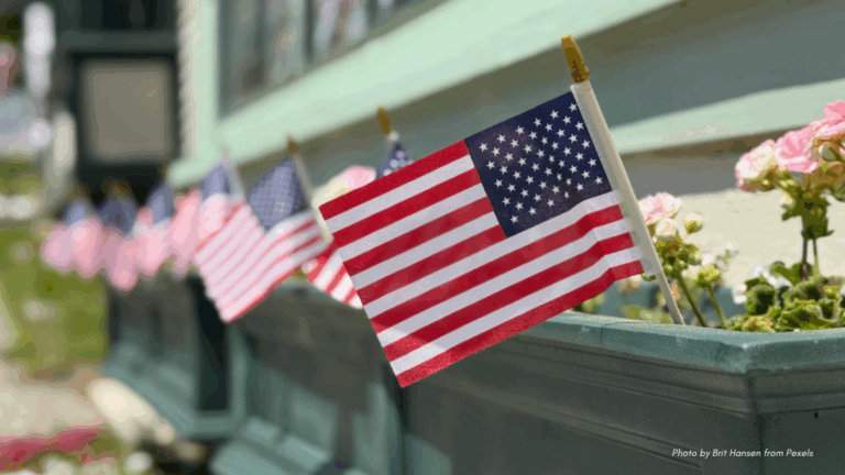 4th of July Potluck etiquette | green window box with blush flowers and American flags
