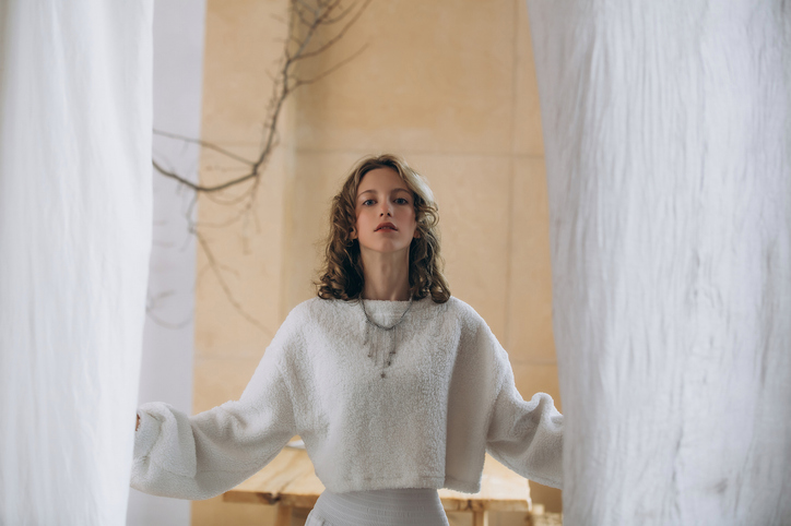 Can I wear white after Labor Day? | The model is a young beautiful girl in a white sweater in a cozy interior in warm colors