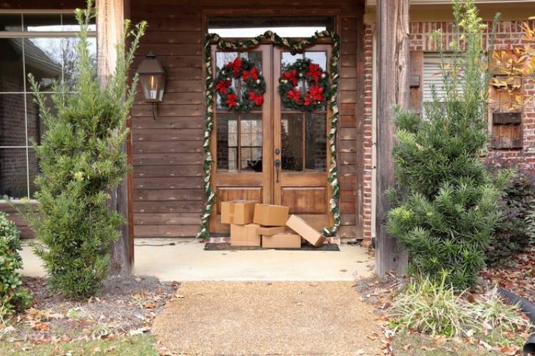 Packages on holiday porch, wreaths on door