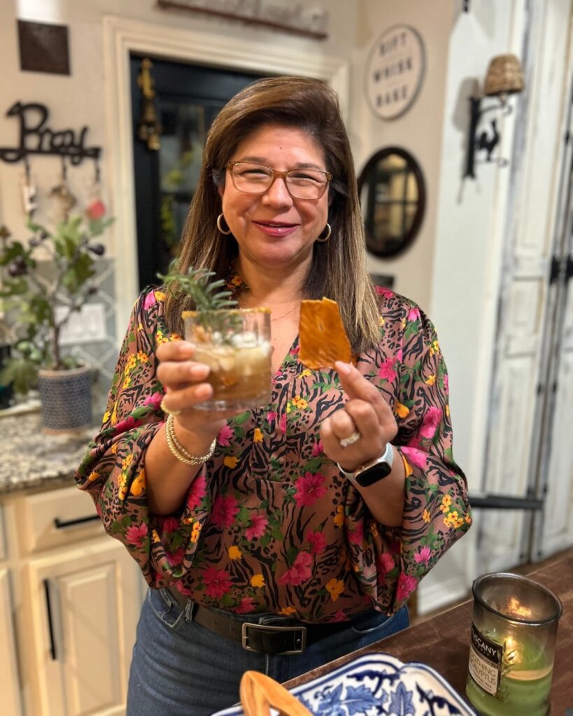 Friend at Friendsgiving holding signature cocktail, wearing festive animal print shirt with flowers