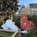 2025 reflections from Diane Gottsman | photo taken in Strasbourg, Germany with large, wooden holiday decorations and ornaments in a beautiful tree outdoors