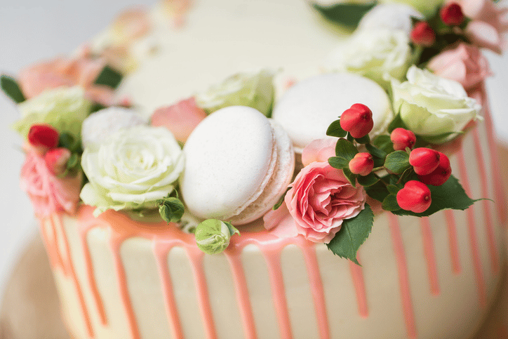 Shower Etiquette | pink and cream colored cake with fresh flowers and macarons